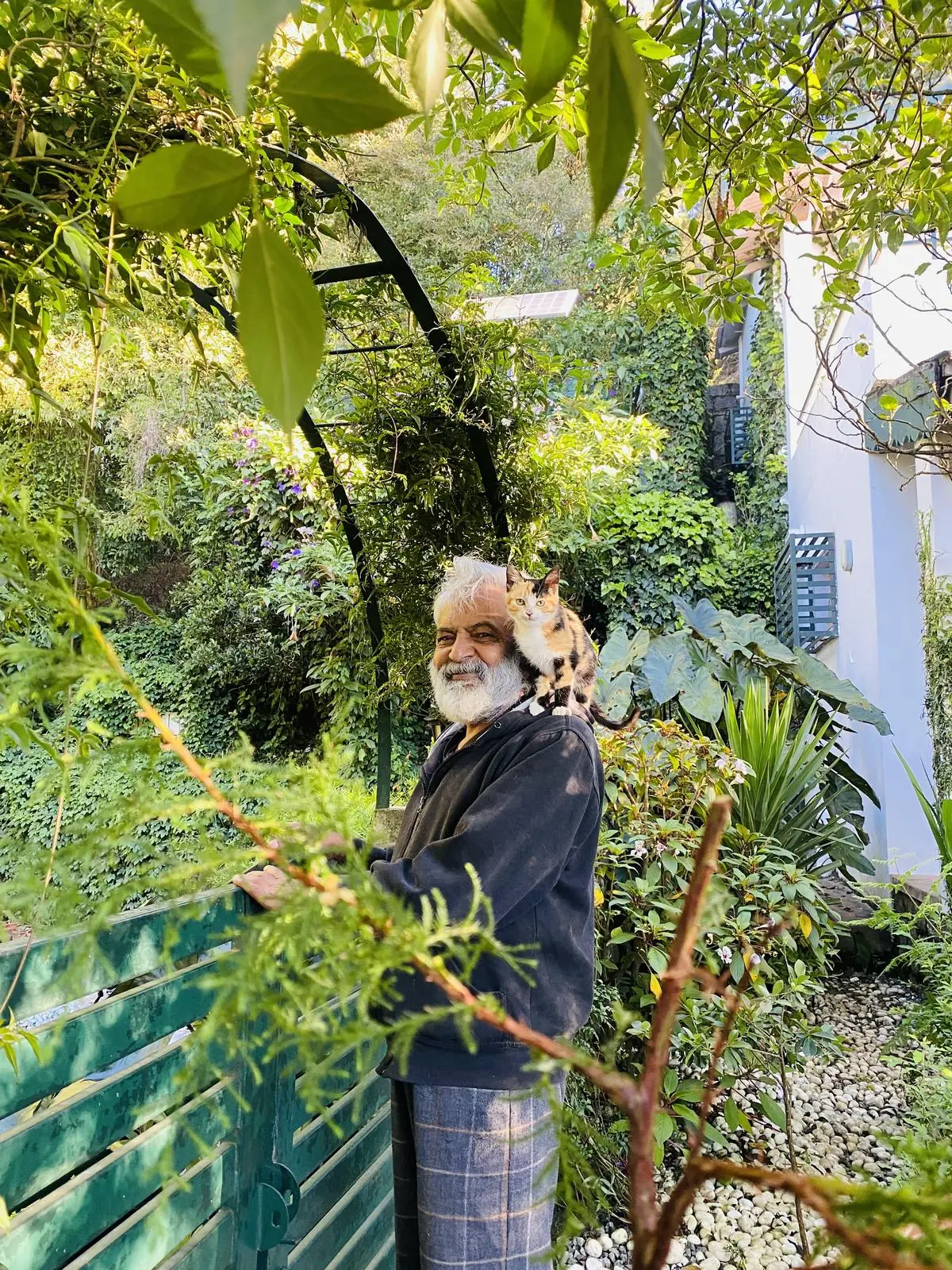 The late Mr K. Nagaraj, our founder, with one of the resident cats on his shoulder in the garden
