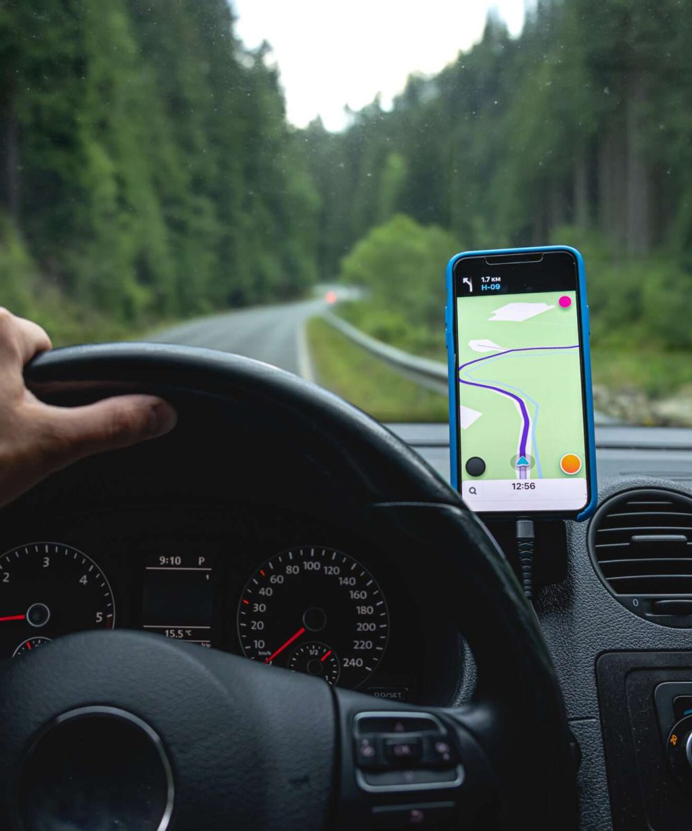 A man is driving on a gps navigator in a mountainous area, a view from inside the car.